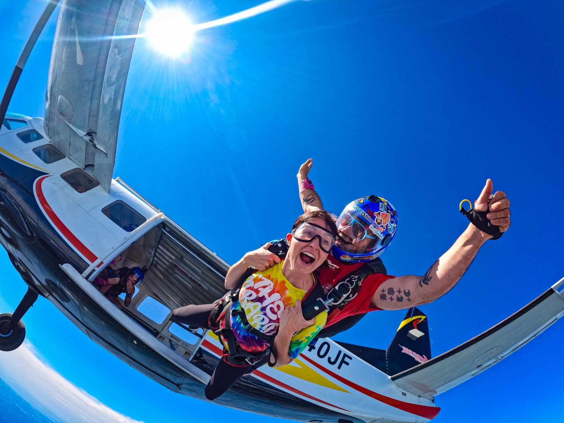 tandem skydiver exiting aircraft at altitude
