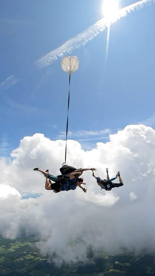 jumpers in skydiving clothing smiling for the camera